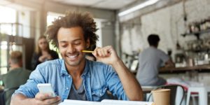 image of male student working at cafeteria doing his home assigment